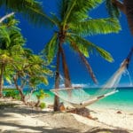 Empty hammock in the shade of palm trees on tropical Fiji Islands