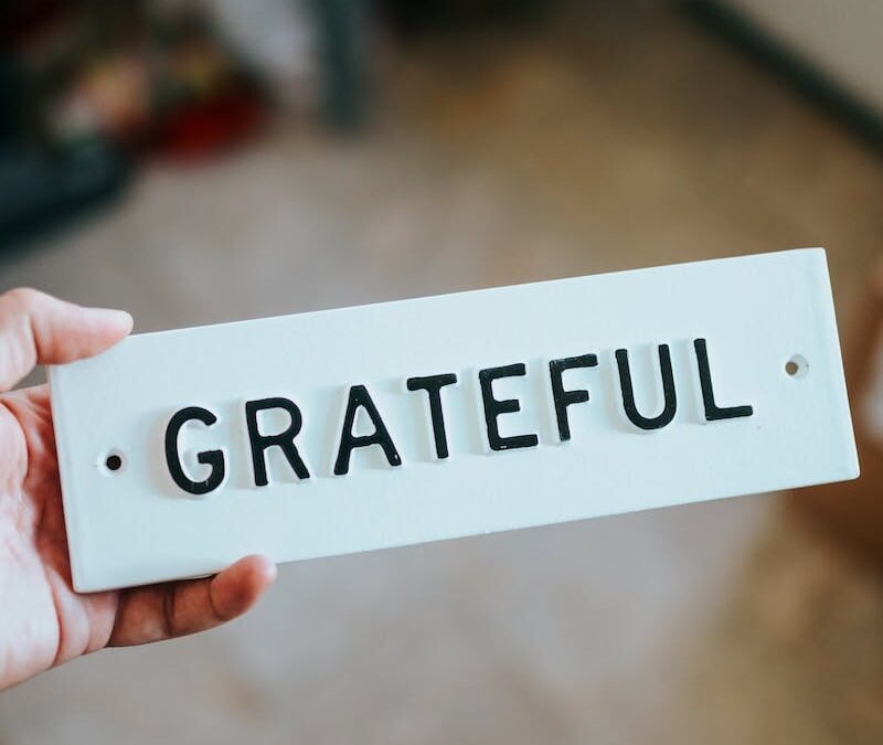 person holding white and black sign that says Grateful